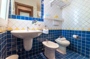 a blue and white bathroom with a sink and a toilet at Riviera Residence in Rimini