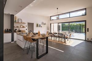 an open kitchen and dining room with a table and chairs at Villa Loki - A 700m de la mer ! in Locquirec