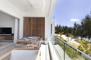 a patio with a table and chairs on a balcony at Seaside Escape with Breathtaking View in Grand Gaube