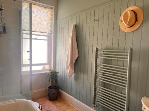 a bathroom with a hat on the wall and a tub at House in Appledore with Hot Tub and own parking in Appledore +45 photos
