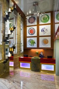 a man sitting at a desk in a lobby at NH Ourense in Ourense