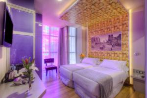 a bedroom with a large white bed and a tv at NH Ourense in Ourense +20 photos