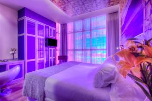 a purple bedroom with a bed and a window at NH Ourense in Ourense