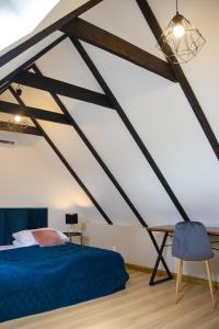 una camera da letto con un letto blu e una sedia di Royal Rooms a Danzica