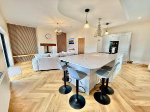 a kitchen and living room with a table and chairs at Jaytrees, Keswick - Luxury bungalow with hot tub in Keswick