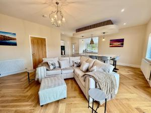 a living room with a couch and a table at Jaytrees, Keswick - Luxury bungalow with hot tub in Keswick