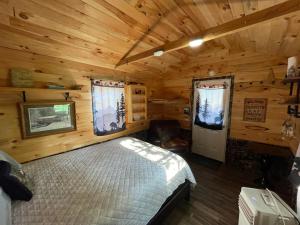 a bedroom with a bed in a wooden cabin at Angies Country Cabins -Off Grid Cabins with shared hot tub access Primitive outhouses Please note This is camping Open year round in Cassadaga