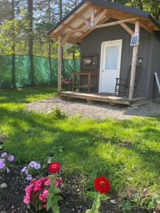 a gazebo with a bench and flowers in the yard at Angies Country Cabins -Off Grid Cabins with shared hot tub access Primitive outhouses Please note This is camping Open year round in Cassadaga +2 photos