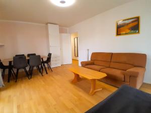 a living room with a couch and a table at Calme & spacieux, RER A 3 min, Parking, 2 salles d'eau in Achères +15 photos