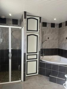 a bathroom with a tub and a shower and a bath tub at Maison de vacances in Ramous