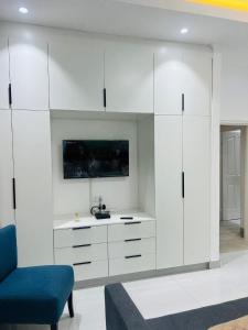 a living room with white cabinets and a blue chair at Tranquil Ridge BnB in Blantyre