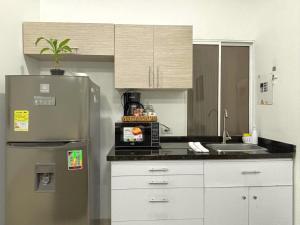 a kitchen with a stainless steel refrigerator and a sink at Casa 106 - Apartaestudios in Cali