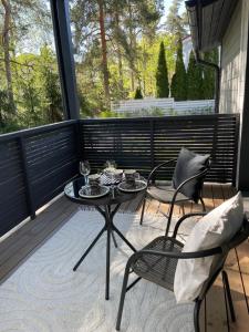 un patio avec deux chaises et une table sur un balcon dans l'établissement Valkovuokko apartment, à Vantaa