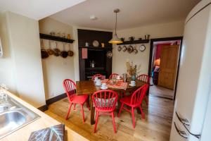 a dining room with a table and red chairs at Cosy Cottage with Spa, Catering, Nature Reserve Walks, Large Garden, Free Parking - Self Checkin in Scunthorpe +286 photos