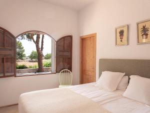 Un dormitorio con una cama blanca y una ventana. en Sa Nau Agroturismo - Adults Only over 16, en Portocolom