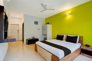 a bedroom with a large bed with a green wall at Townhouse Morjim Beach North Goa Formerly Bay Breeze Hotels & Resorts in Chopdem