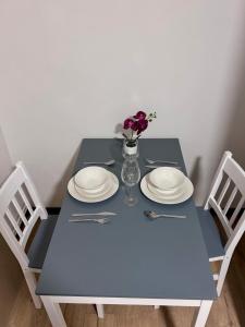 ロンドンにあるRoom in Central London Steps from Eustonの青いテーブルと皿、花瓶