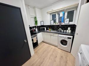 ロンドンにあるRoom in Central London Steps from Eustonのシンクと洗濯機付きのキッチン