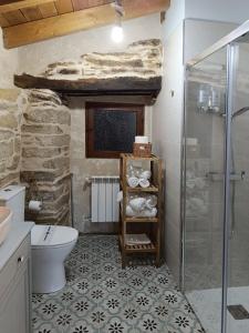 a bathroom with a toilet and a glass shower at Casa Veracruz Sanabria in Puebla de Sanabria +13 photos