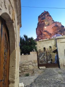 an entrance to a building with a gate with a mountain in the background at Cosy cave suit in Urgup