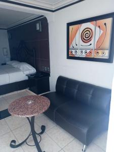 a room with a couch and a table and a bed at motel alamo in Guadalajara