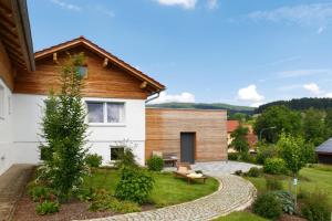 a house with a garden and a bench in the yard at Ferienhaus Schlamminger in Döbersing