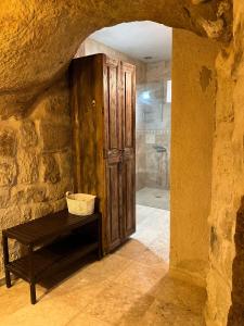 a bathroom with a shower and a wooden door at Cosy cave suit in Urgup +10 photos
