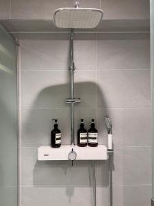 a shelf in a bathroom with three bottles on it at Hotel Myeongdon Station in Seoul
