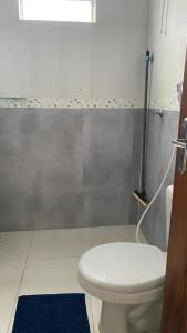 ParagominasにあるCasa prática e aconcheganteのバスルーム(トイレ付)、青いラグ +5枚の写真