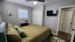 a bedroom with a bed and a flat screen tv at Little House in Indy sleeps many in Indianapolis