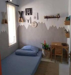 a bedroom with a blue bed and a desk at Dulcon278 in Sukarami