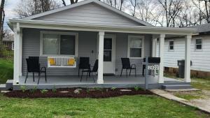 a house with a porch with chairs and a table at Little House in Indy sleeps many in Indianapolis