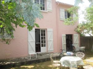 a pink house with a table in front of it at la villa rose in Saint-Trojan-les-Bains