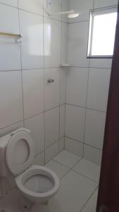 a white bathroom with a toilet and a window at Casa Machado in Conde