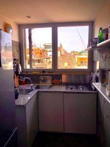 a kitchen with a sink and a window with a view at Private terrace penthouse with elevator Piazza Spagna in Rome +17 photos