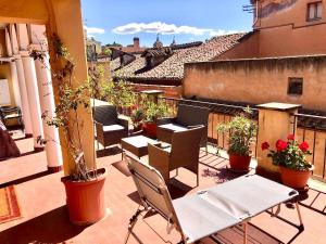 a balcony with chairs and potted plants on a building at Private terrace penthouse with elevator Piazza Spagna in Rome