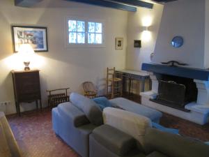 a living room with a couch and a fireplace at la villa rose in Saint-Trojan-les-Bains