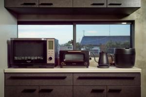 a kitchen counter top with a microwave and a television at COCO VILLA 九十九里一宮-Sauna- in Ichigaya