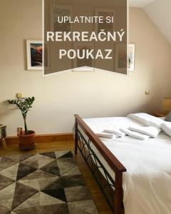 a bedroom with a bed with a sign on the wall at Apartmán Juli in Tatranská Lomnica