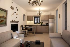 a living room with a couch and a kitchen at Simo's Apartments in Egina