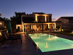 a house with a swimming pool in front of a house at Urla Villa in Urla