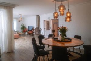 a living room with a table with chairs and a fireplace at Puur17 in Lommel