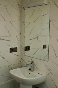 a white bathroom with a sink and a mirror at Dar Iziki Separate Apartment in Sidi Kaouki +58 photos