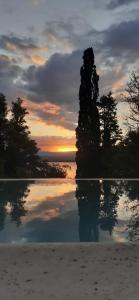 a sunset over a body of water with trees at Vista Alago in Villa Ciudad Parque