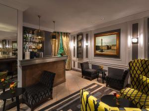 a lobby with a bar with chairs and tables at Le Stendhal - Vendôme in Paris