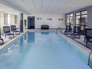a pool in a hotel room with chairs around it at Hotel Mercure Blois Centre in Blois