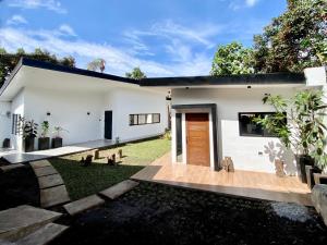 a white house with a wooden door and a yard at Unica Hija Hometel by TahZora in Valencia