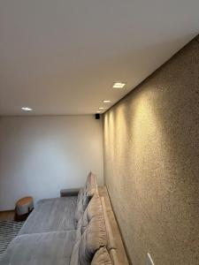 a bedroom with a bed against a wall at Belíssimo Apartamento Aeroporto in Várzea Grande