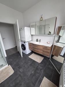 a bathroom with a sink and a washing machine at FlexHome Gemütliche Ferienwohnung in Lippstadt