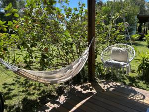 eine Hängematte und ein Stuhl auf einer Veranda in der Unterkunft Mucho cielo y mucho mar in Punta Colorada